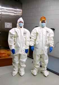 University of Tennessee, Knoxville grad students Angela Dautartas and Jake Smith (wearing hat) take proper precautions when handling human remains.